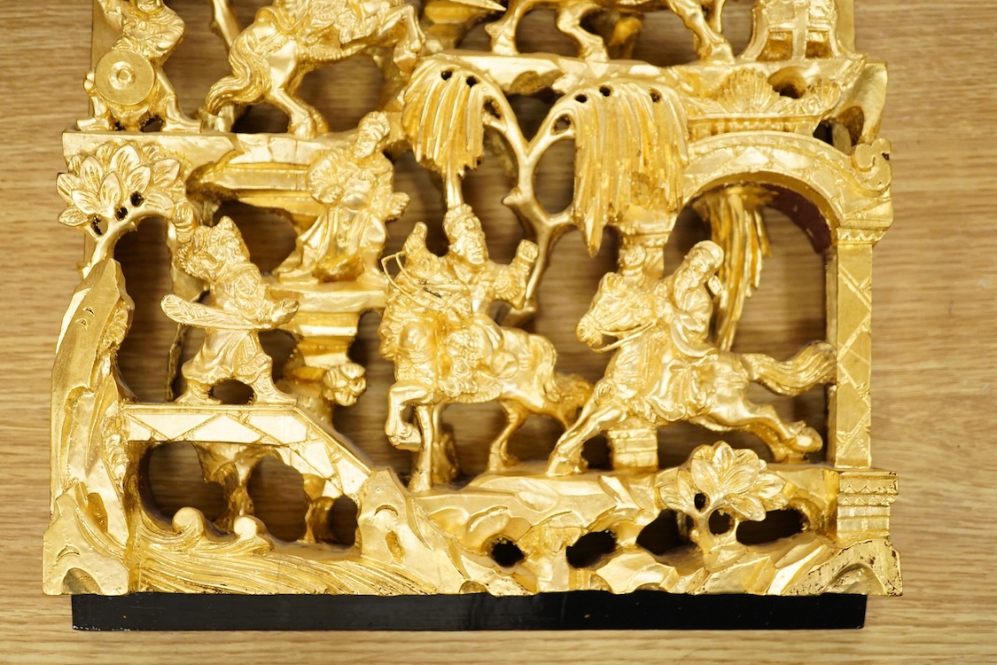 A Chinese carved gilt wood panel, depicting battle scenes, 50cm high